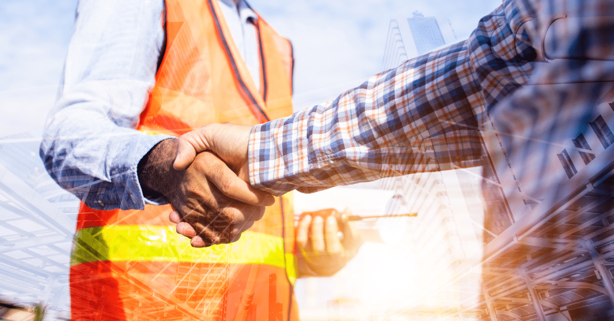 Foreman and construction employee in safety vest shaking hands